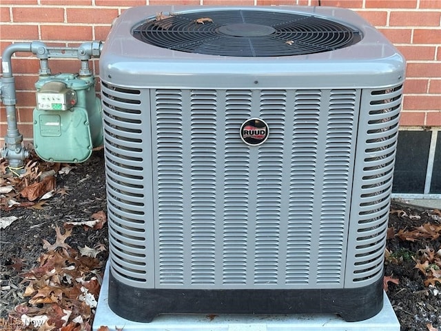 details featuring central AC, brick siding, and gas meter