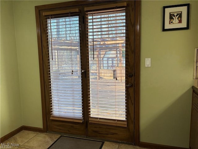 interior space featuring baseboards and light tile patterned flooring