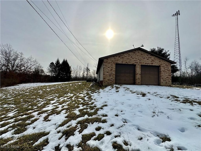 snow covered garage with a garage