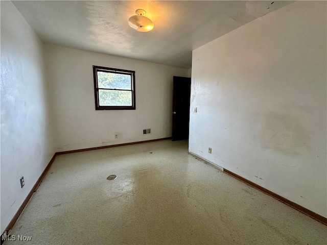 empty room featuring visible vents and baseboards