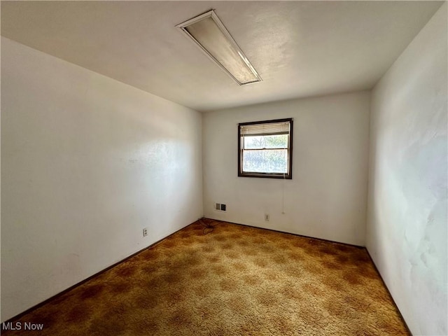 unfurnished room with carpet floors and visible vents