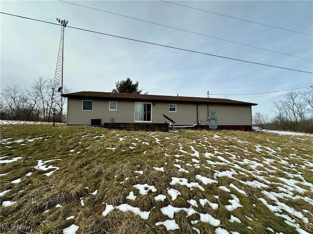 snow covered house featuring central air condition unit