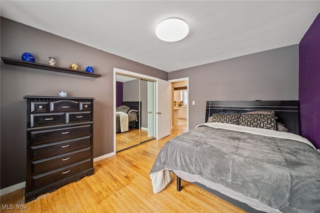 bedroom featuring light wood finished floors, a closet, and baseboards