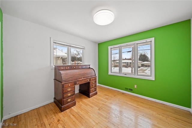 office space with light wood finished floors, baseboards, and visible vents