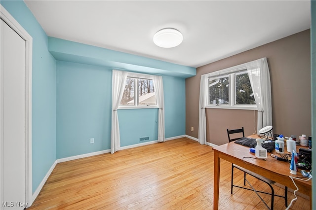 office space with visible vents, baseboards, and wood finished floors