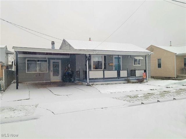 snow covered property with covered porch