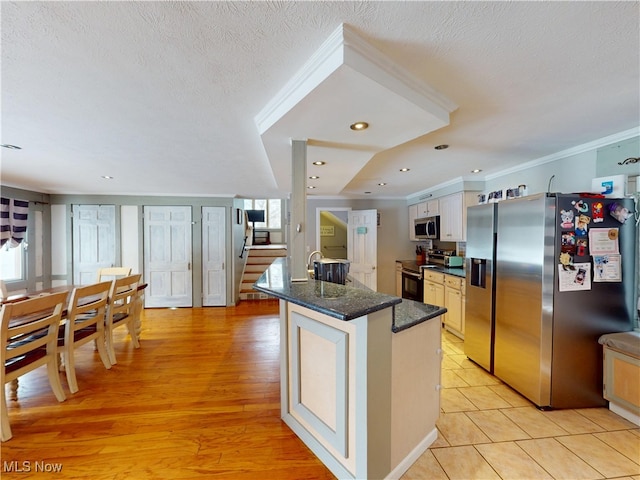 kitchen featuring a center island with sink, crown molding, stainless steel appliances, white cabinets, and a textured ceiling