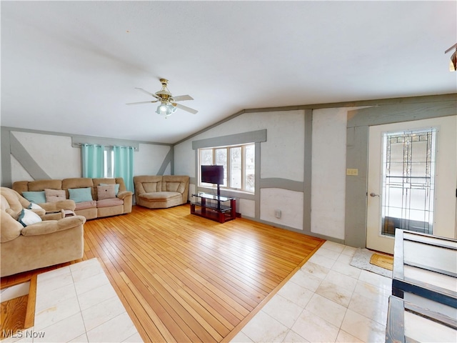 unfurnished living room featuring lofted ceiling, light wood-type flooring, and a ceiling fan