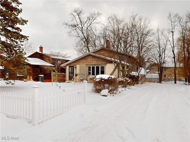 snow covered property with a chimney