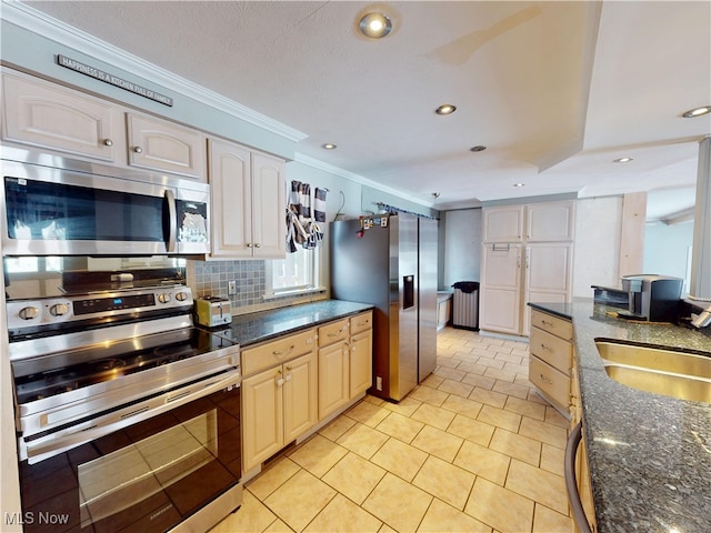 kitchen with a sink, appliances with stainless steel finishes, backsplash, dark stone counters, and crown molding