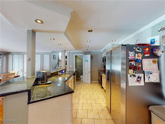 kitchen with appliances with stainless steel finishes, recessed lighting, a sink, and ornamental molding