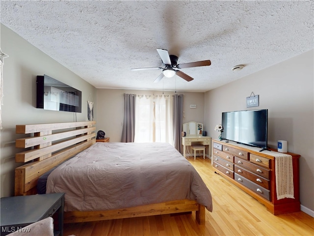 bedroom featuring ceiling fan, a textured ceiling, and wood finished floors