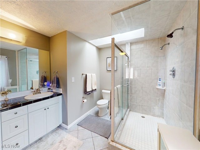 full bathroom with a stall shower, baseboards, toilet, tile patterned floors, and vanity