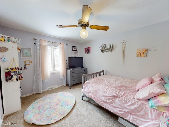 bedroom with ceiling fan, visible vents, baseboards, and light colored carpet