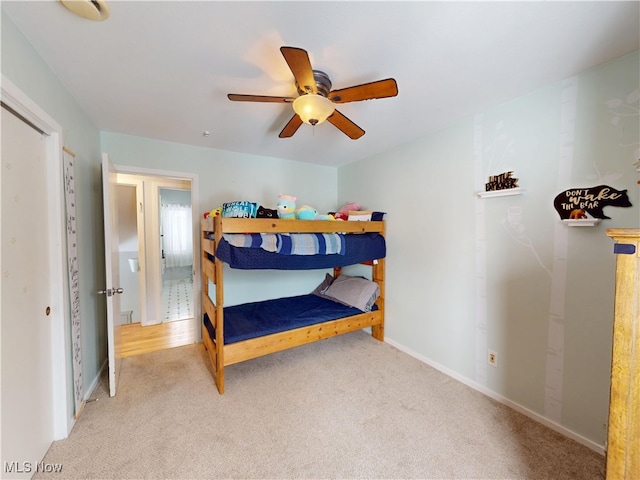 bedroom with a ceiling fan, light carpet, and baseboards