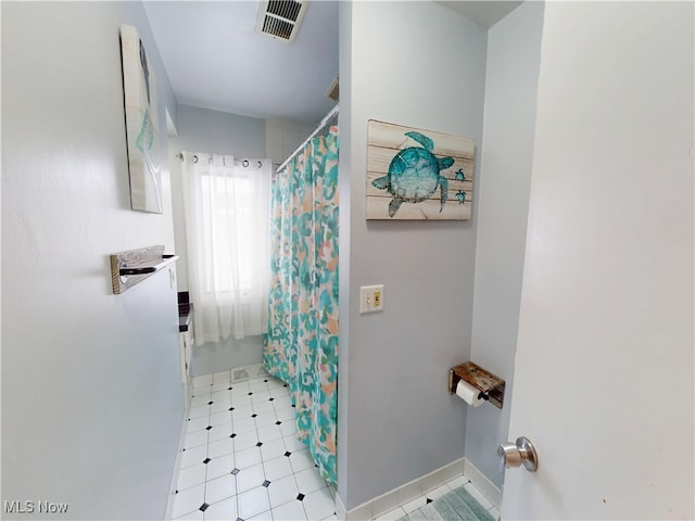 bathroom featuring a shower with curtain, tile patterned floors, visible vents, and baseboards