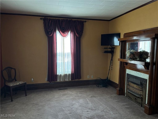 carpeted living area featuring a fireplace, crown molding, and baseboards