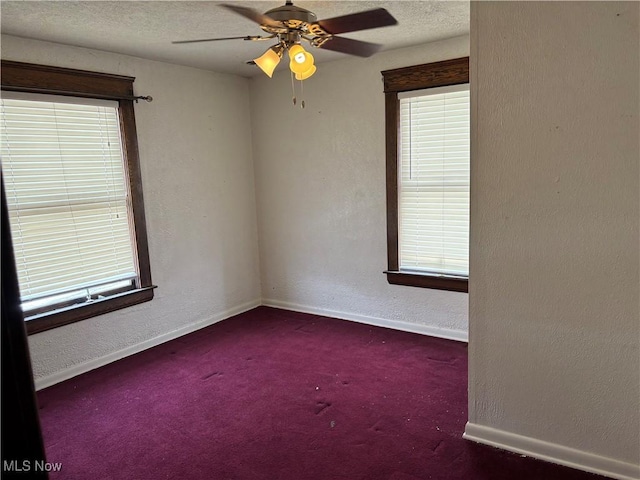 empty room with baseboards, a textured ceiling, and a textured wall