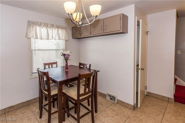 dining area featuring light tile patterned floors, baseboards, visible vents, and a notable chandelier