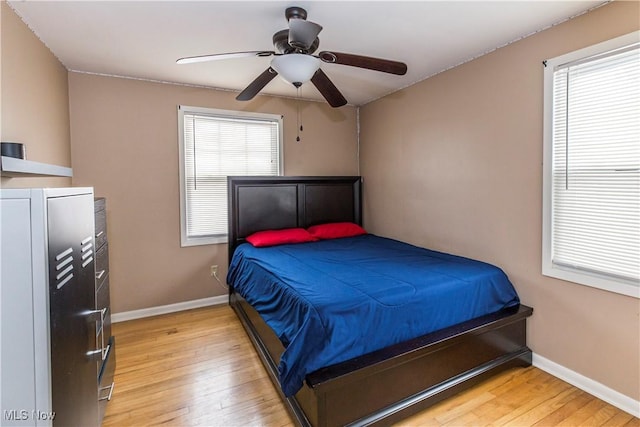 bedroom featuring ceiling fan, baseboards, and wood finished floors