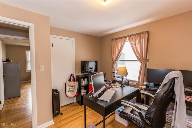 office area featuring light wood-style flooring and baseboards