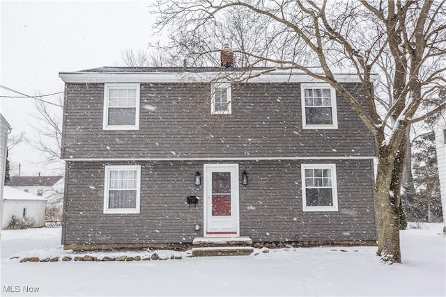 view of front of property featuring entry steps and a chimney