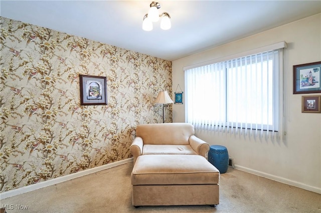 sitting room with wallpapered walls, carpet, and baseboards