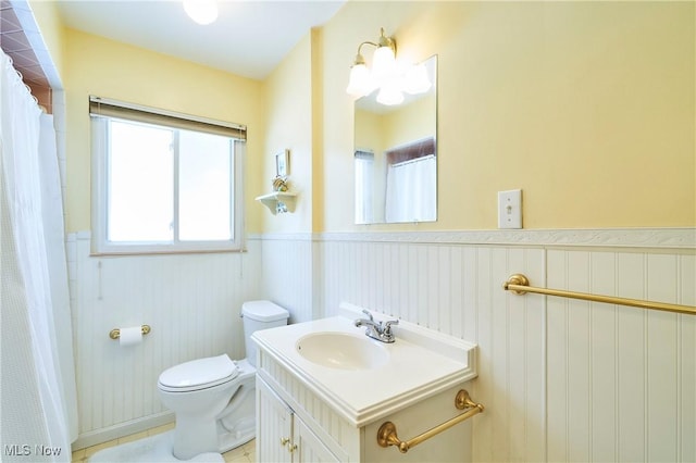 bathroom featuring wainscoting, vanity, and toilet