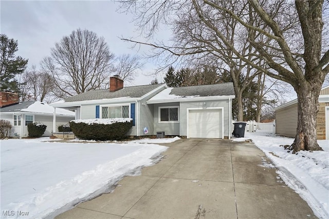 single story home with driveway, a chimney, and an attached garage