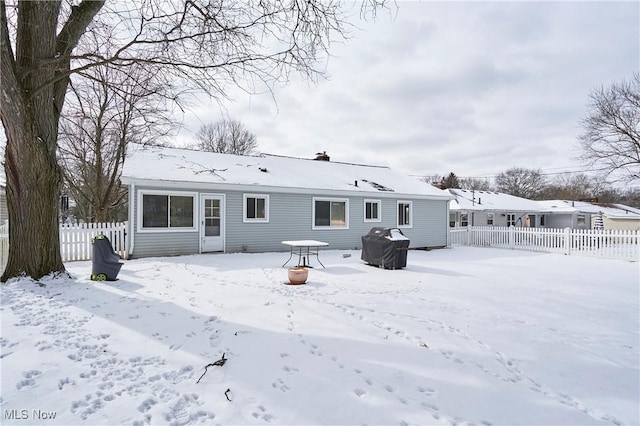 snow covered back of property with fence