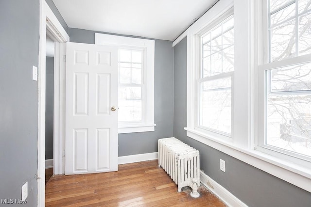 entryway featuring baseboards, light wood-style flooring, and radiator