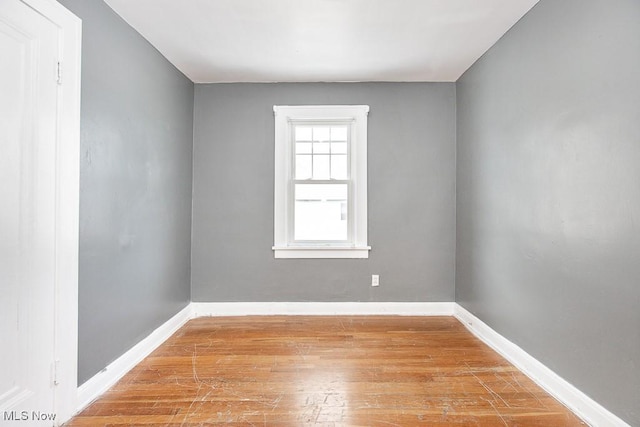 spare room featuring light wood finished floors and baseboards