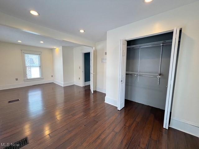 unfurnished bedroom featuring dark wood finished floors, recessed lighting, a closet, visible vents, and baseboards