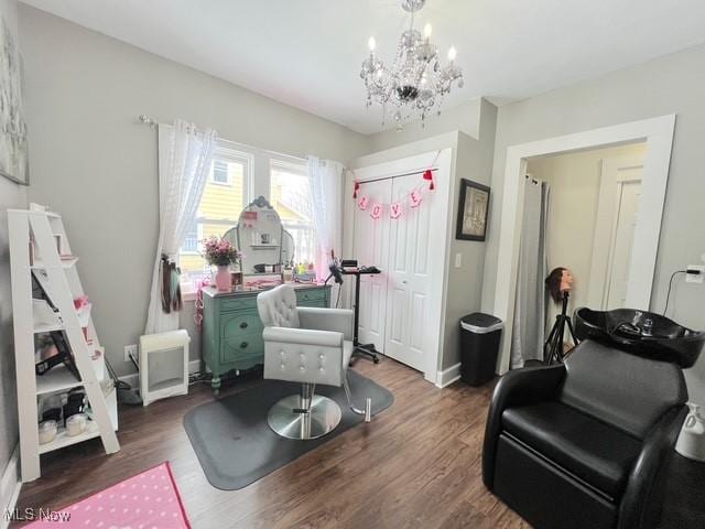 rec room with a chandelier and dark wood-style flooring