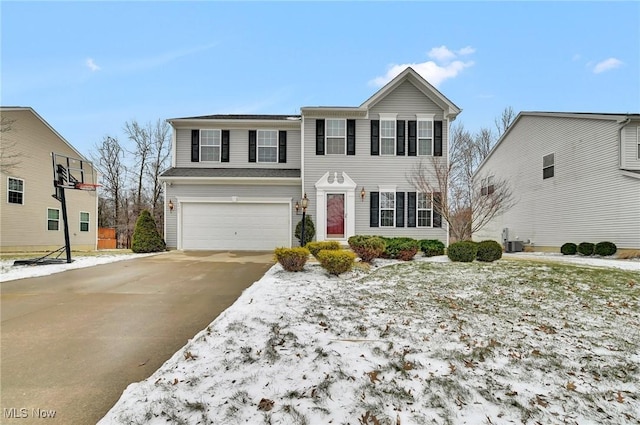 view of front of home with driveway, an attached garage, and central AC unit