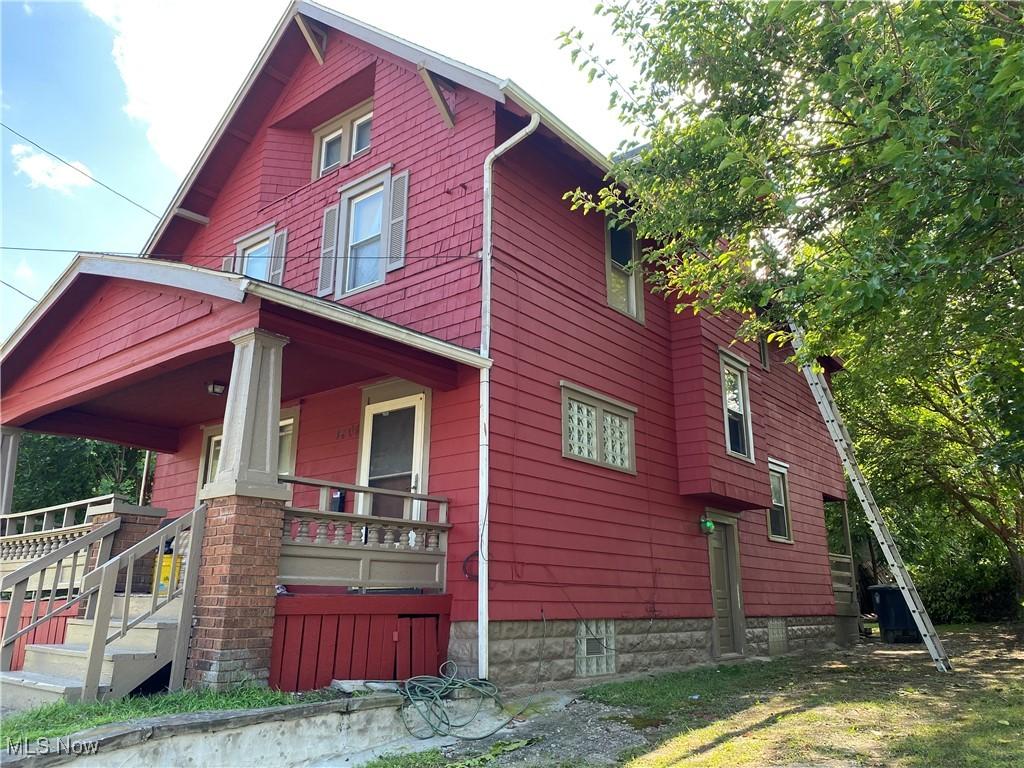 view of side of property with a balcony and a porch