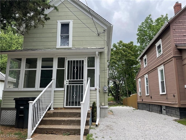 view of front of house with entry steps and a sunroom