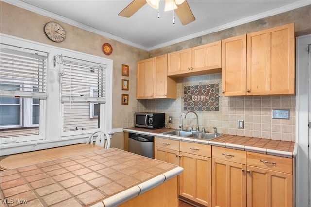 kitchen featuring tile counters, stainless steel appliances, decorative backsplash, light brown cabinetry, and a sink