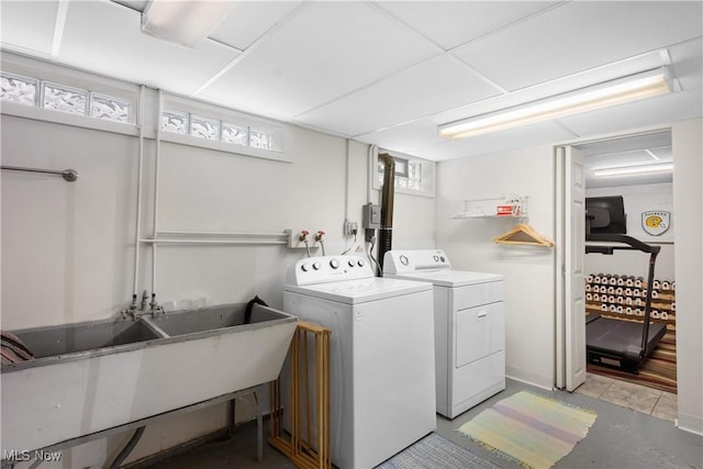 laundry room with laundry area, independent washer and dryer, and a sink