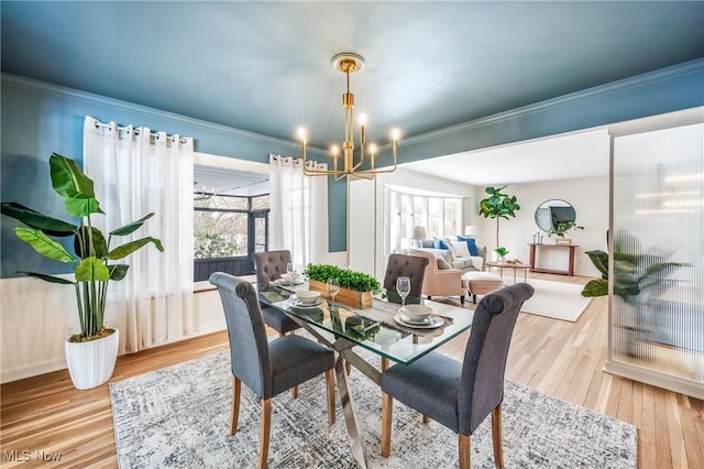 dining area featuring ornamental molding, wood finished floors, and an inviting chandelier