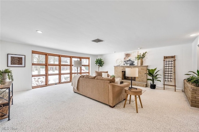 living room featuring recessed lighting, a brick fireplace, visible vents, and light colored carpet