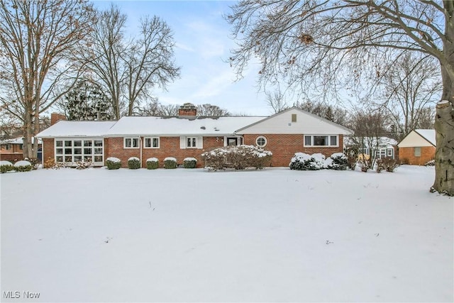 view of front of home featuring brick siding and a chimney