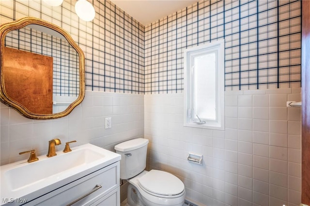 half bath featuring toilet, a wainscoted wall, vanity, and wallpapered walls