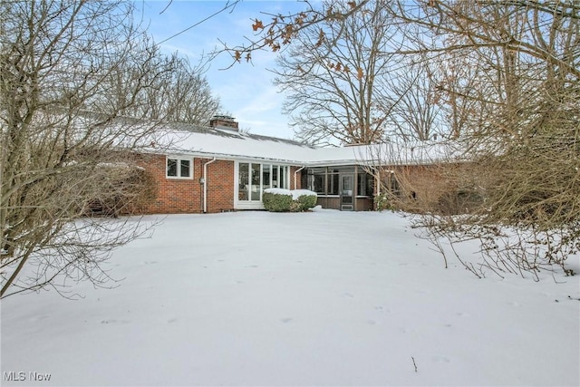 view of front of house with brick siding and a chimney