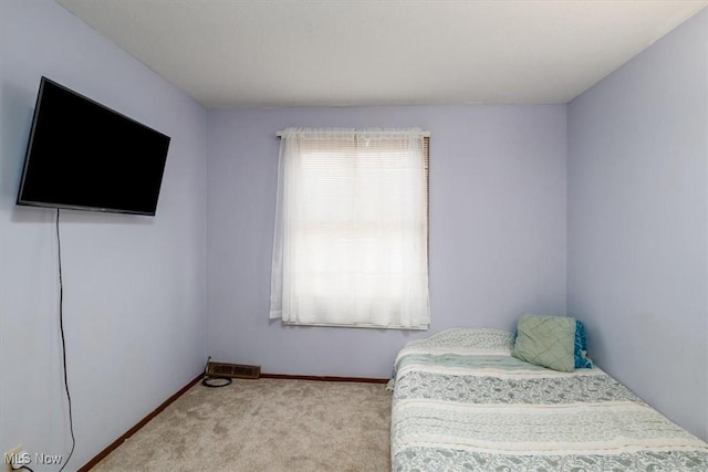 bedroom with baseboards and light colored carpet