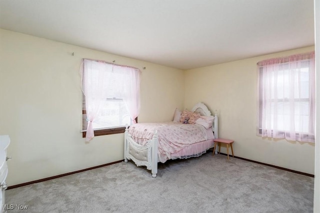 bedroom with light carpet and baseboards