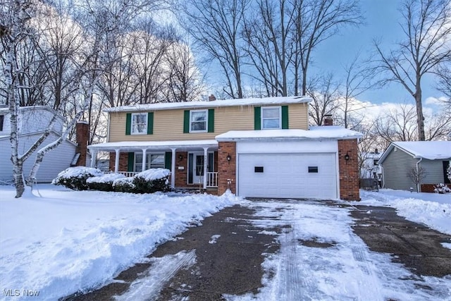 traditional home with a porch, aphalt driveway, and brick siding