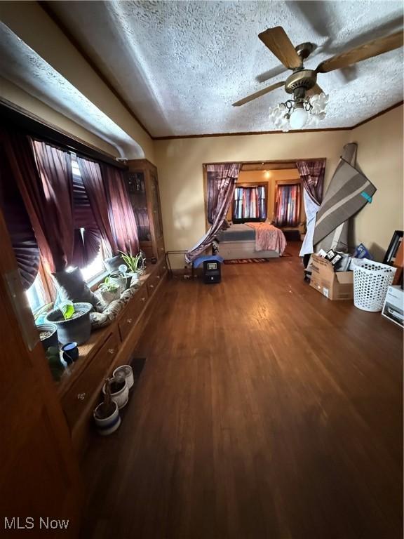 unfurnished bedroom with ornamental molding, a textured ceiling, and wood finished floors