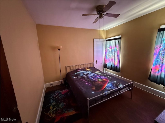 bedroom featuring ceiling fan, wood finished floors, and baseboards