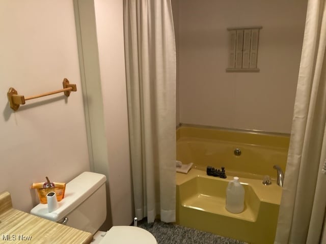 bathroom featuring toilet and a bath